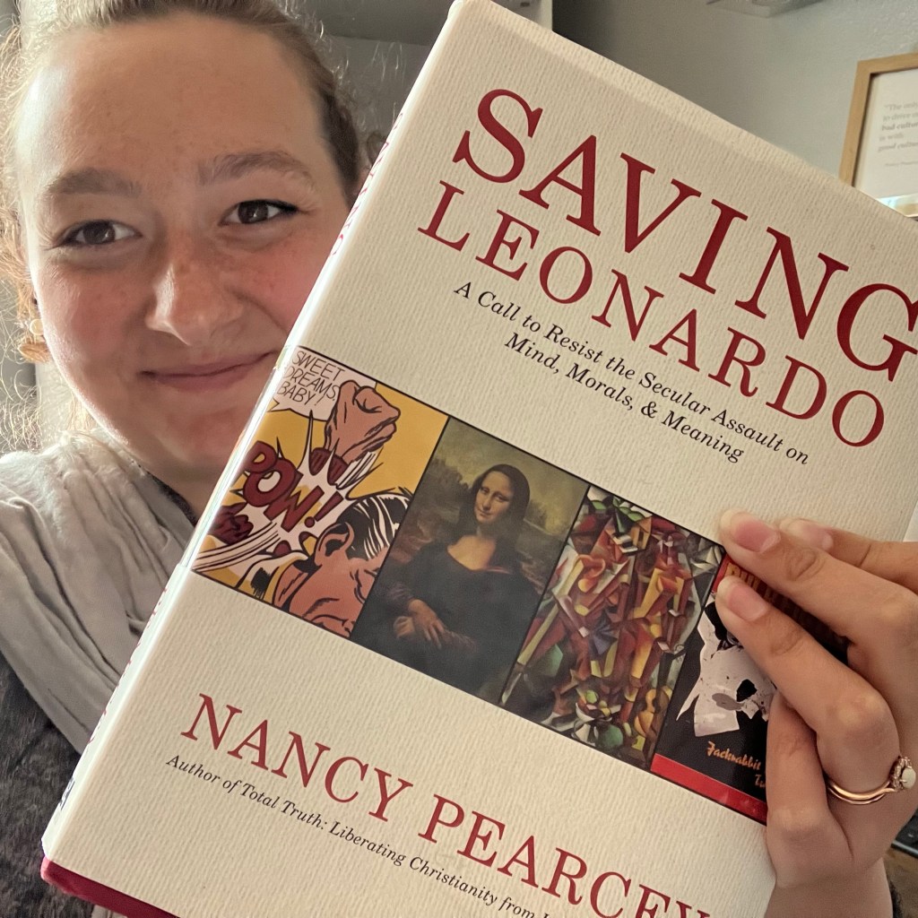 Julia holding a copy of "Saving Leonardo" by Nancy Pearcey
